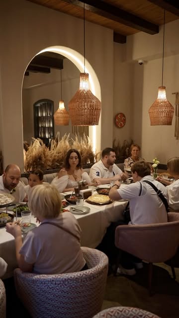 Familie la masă sub arcada luminată din sala Tbiliso